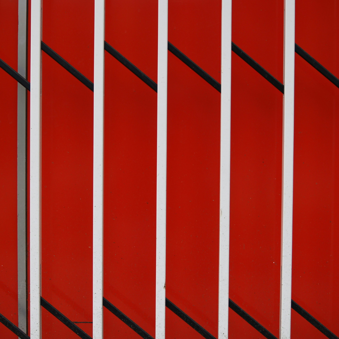 Pattern geometrico rosso con linee bianche e nere, simbolo del rosso come colore della vita e della forza nella simbologia cromatica.